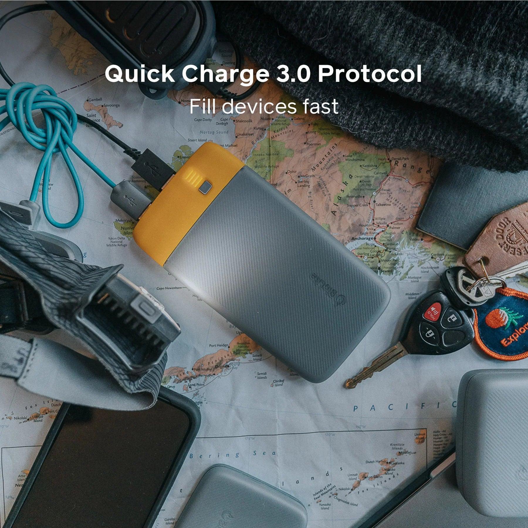 BioLite power bank on a map with charging cables, keys, and outdoor gear for travel