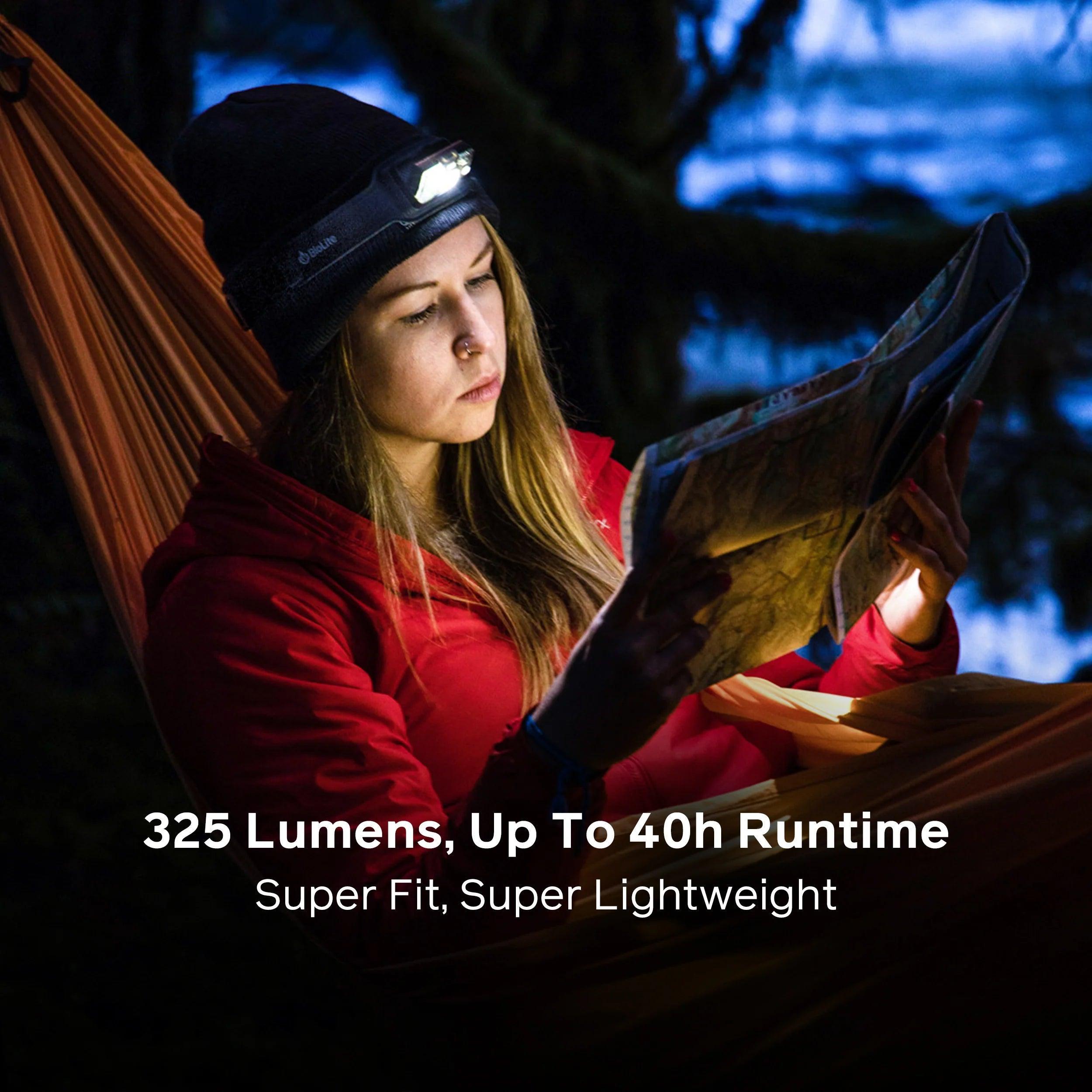 Woman in hammock reading map at night with BioLite headlamp, outdoor adventure gear