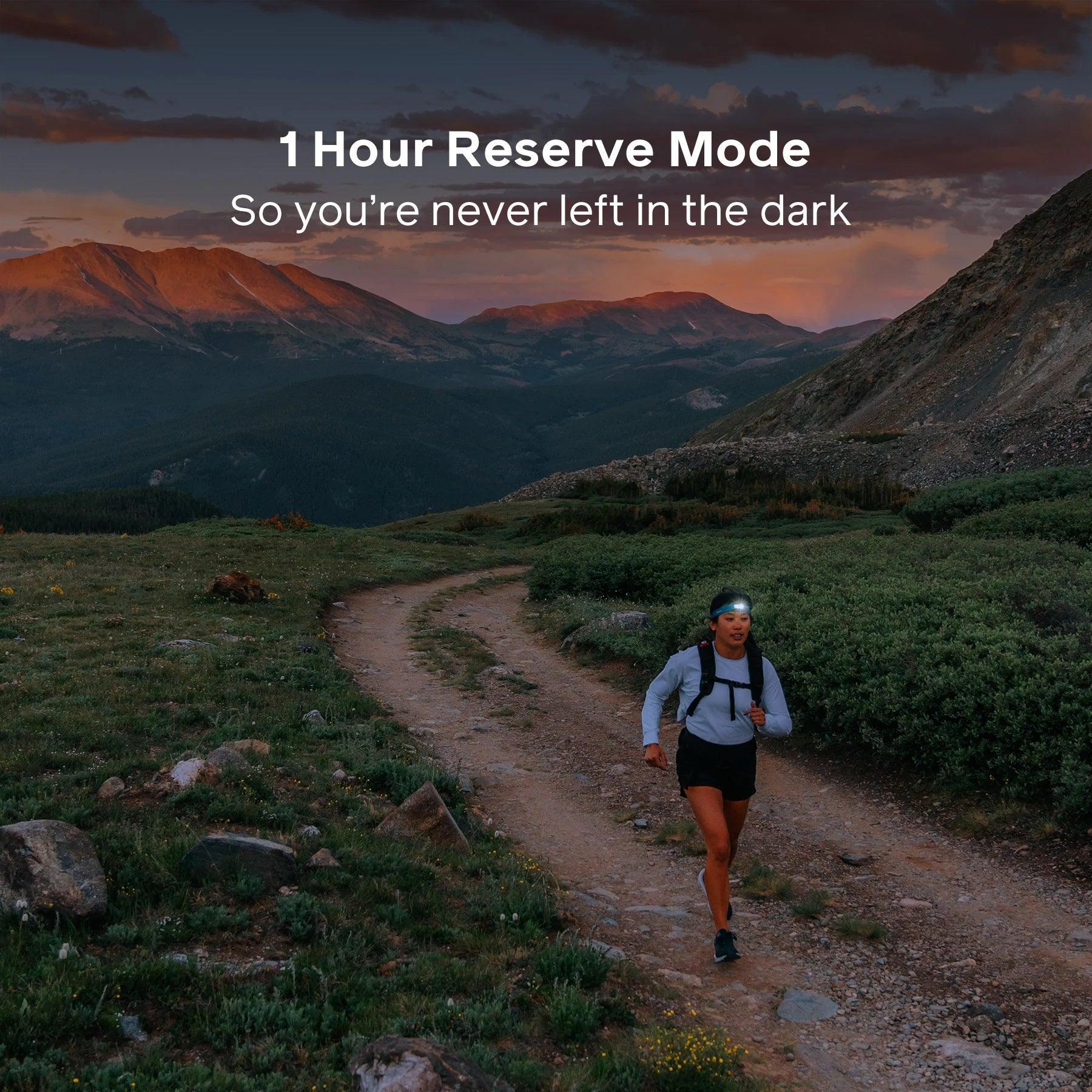 Trail runner at dusk wearing BioLite HeadLamp 425, mountain landscape in background