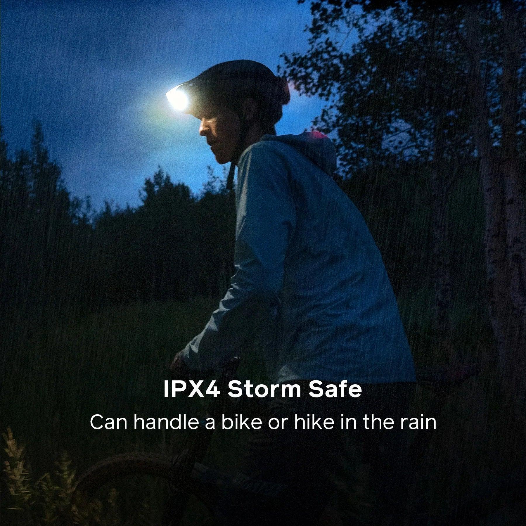 Cyclist wearing a headlamp in the rain at dusk, demonstrating IPX4 storm safe outdoor gear.