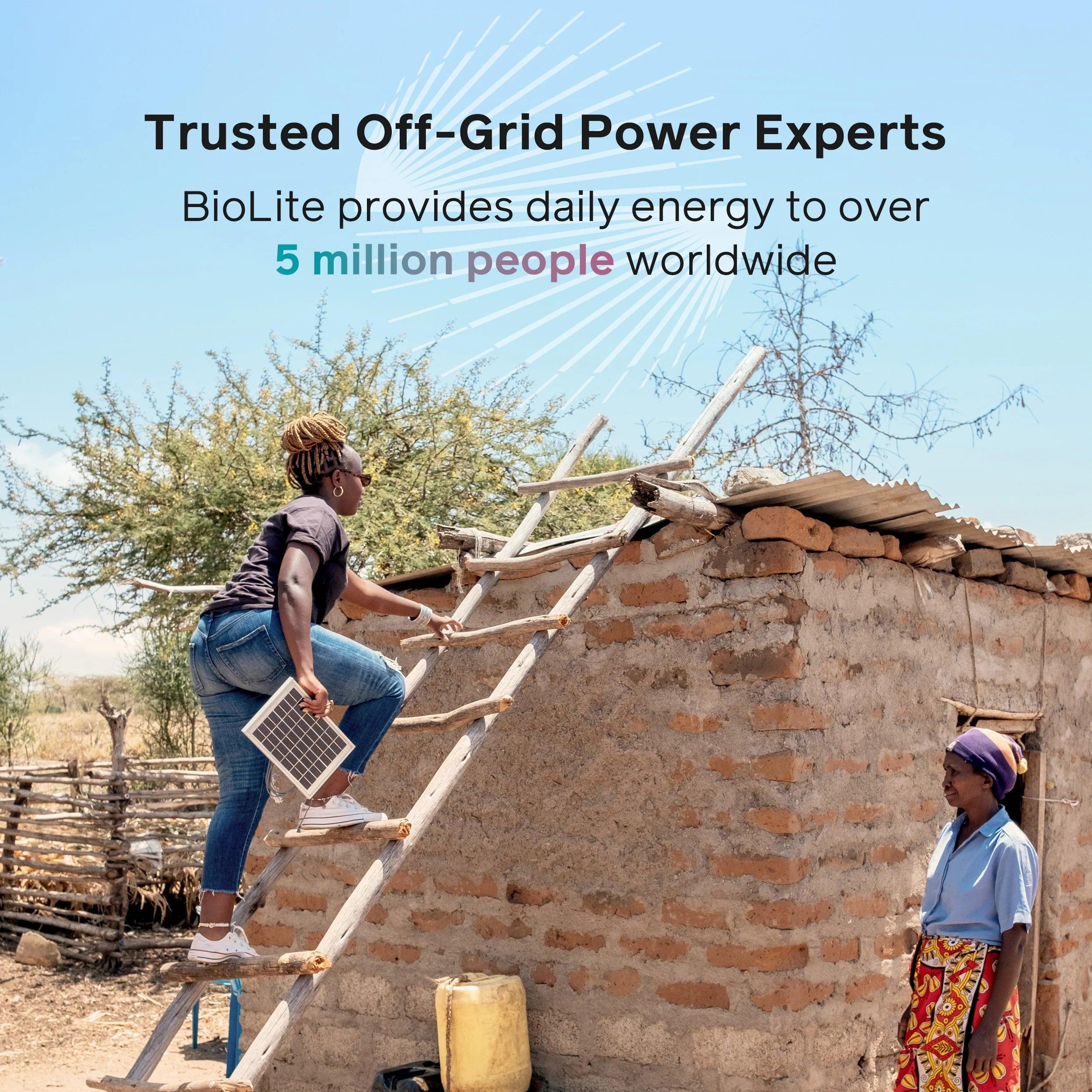Woman installing BioLite solar panel on rural house roof, off-grid renewable energy concept