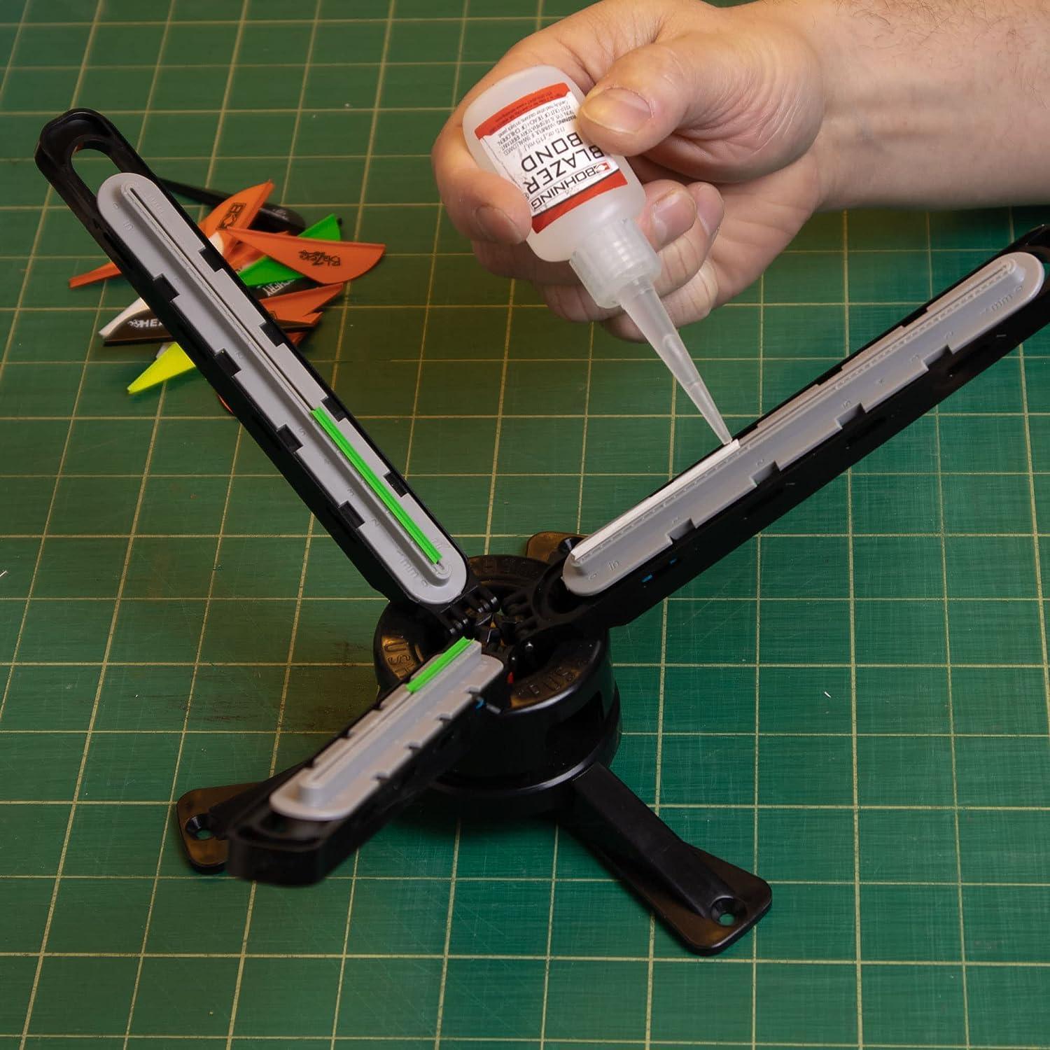 Hand applying Bohning Blazer Bond glue to arrow fletching jig on green cutting mat