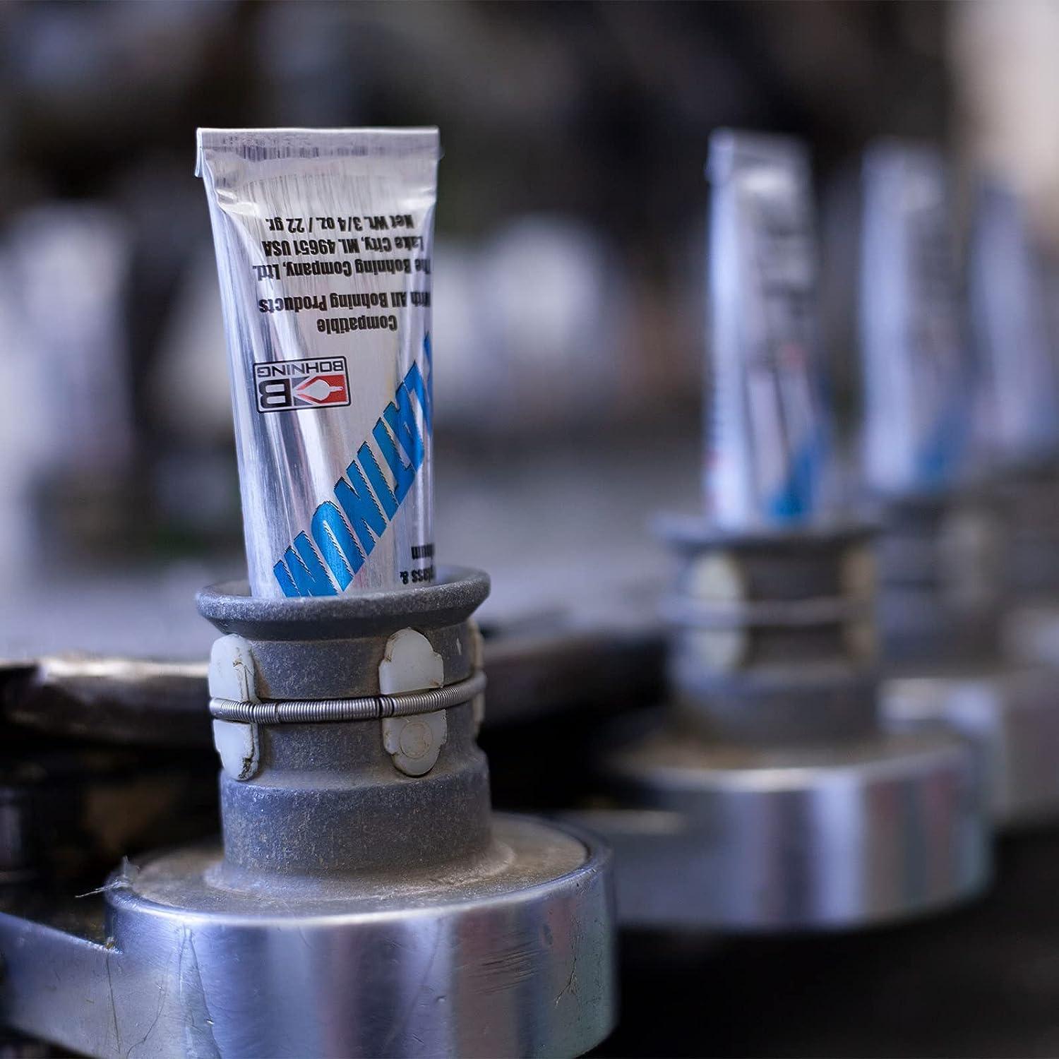 Bohning Fletch-Tite Platinum glue 3/4 oz tube on metal assembly line, close-up