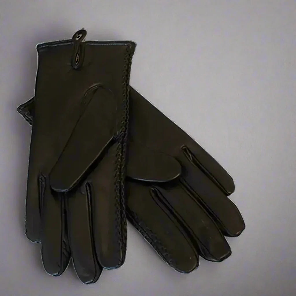 Large black leather gloves on a plain background