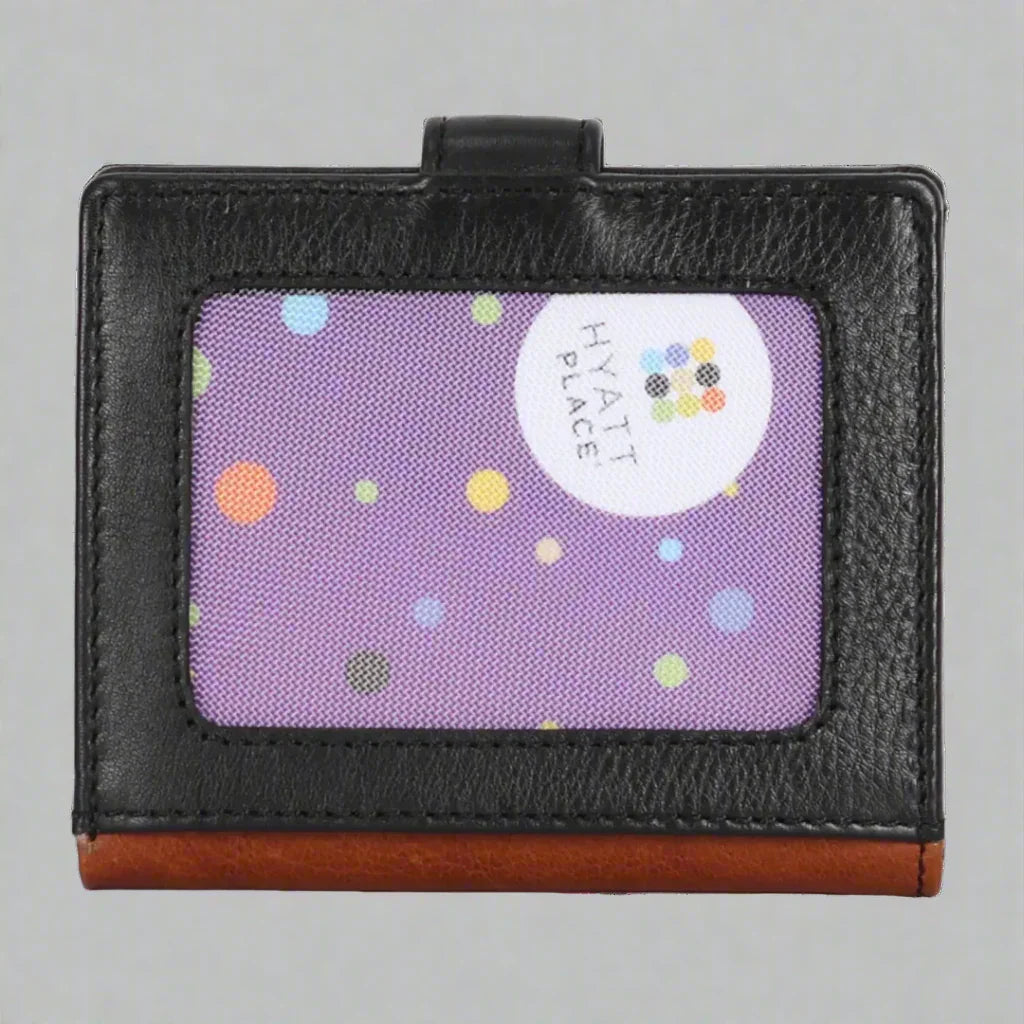 Black leather card holder with brown trim and Hyatt Place logo on purple polka dot background