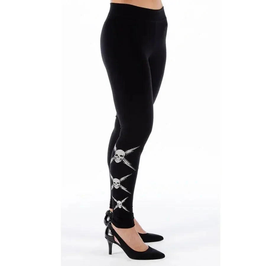 Women's black leggings with rhinestone skull design, paired with black heels on white background
