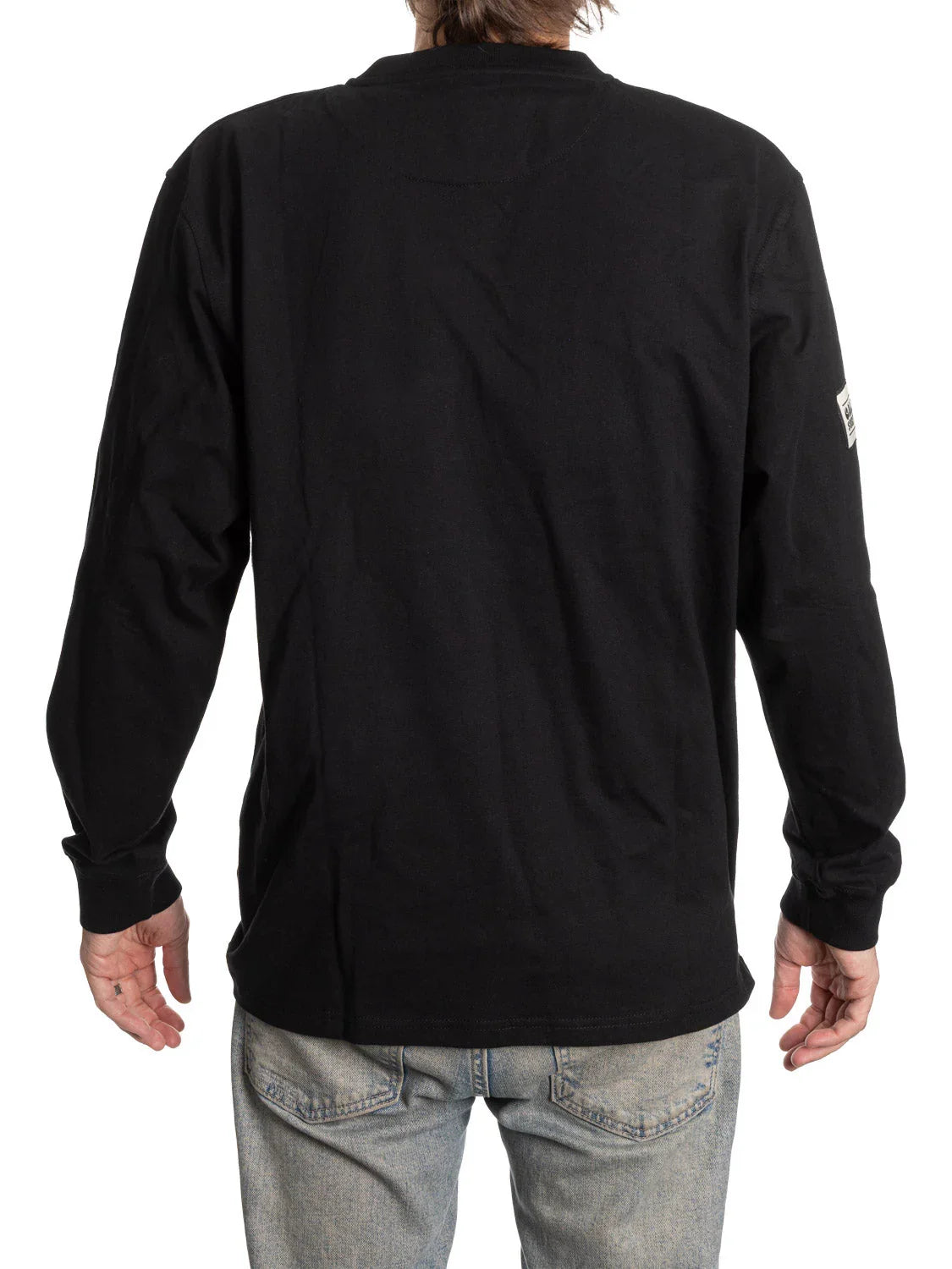 Back view of person wearing black long sleeve Henley shirt and light blue jeans