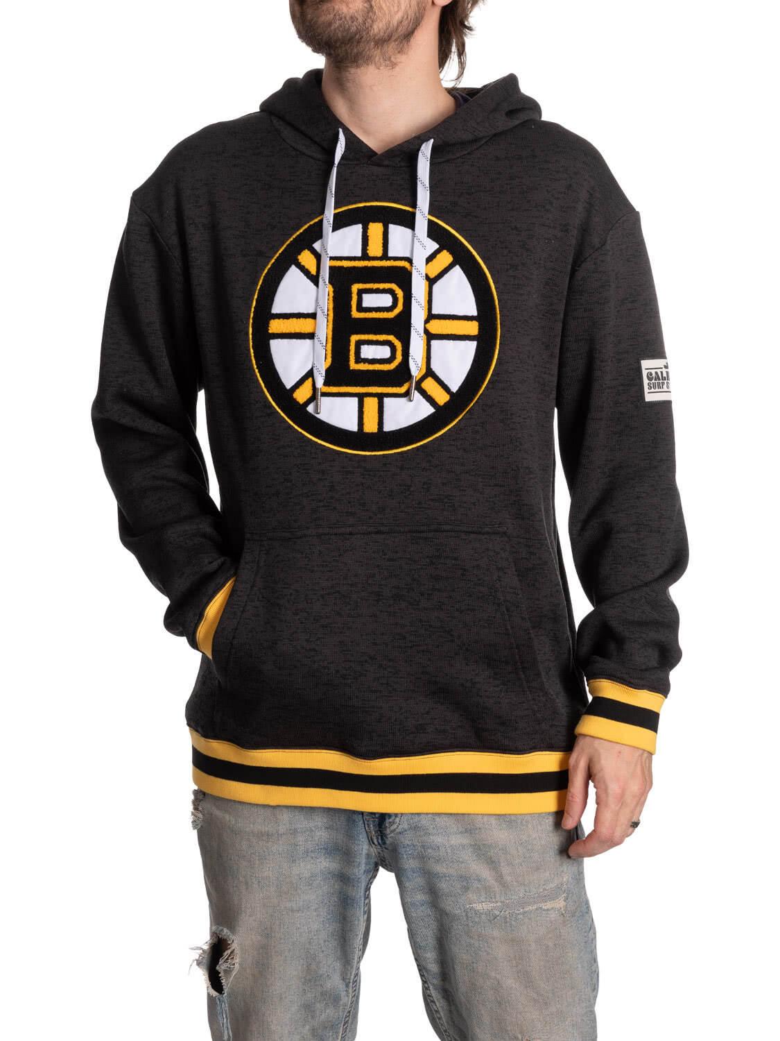Man wearing black Boston Bruins hoodie with yellow trim and distressed jeans