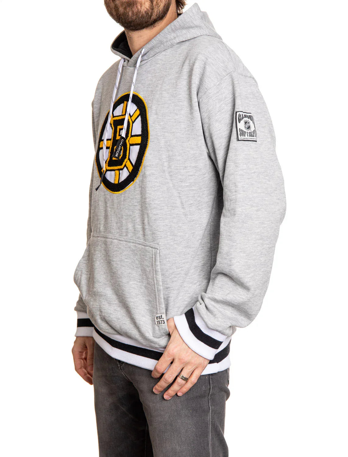 Man wearing gray Boston Bruins chenille hoodie with logo and striped cuffs