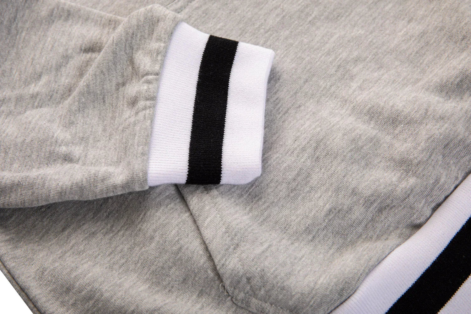 Grey hoodie close-up with black and white striped ribbed cuff and waistband