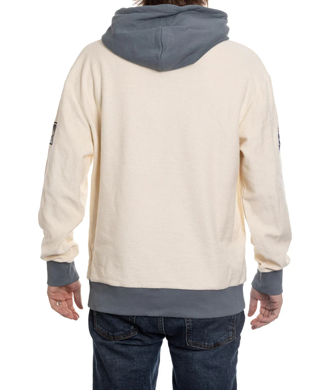 Back view of person wearing cream Boston Bruins reverse hoodie with gray hood and cuffs