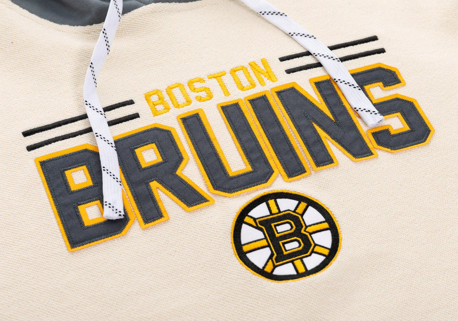 Boston Bruins logo and embroidery detail on cream hockey hoodie with drawstrings