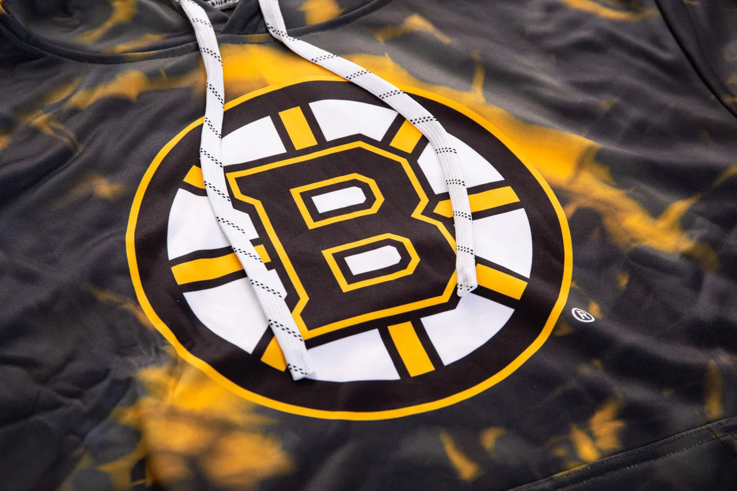 Boston Bruins sublimated hoodie detail with black, yellow, and white logo and drawstrings