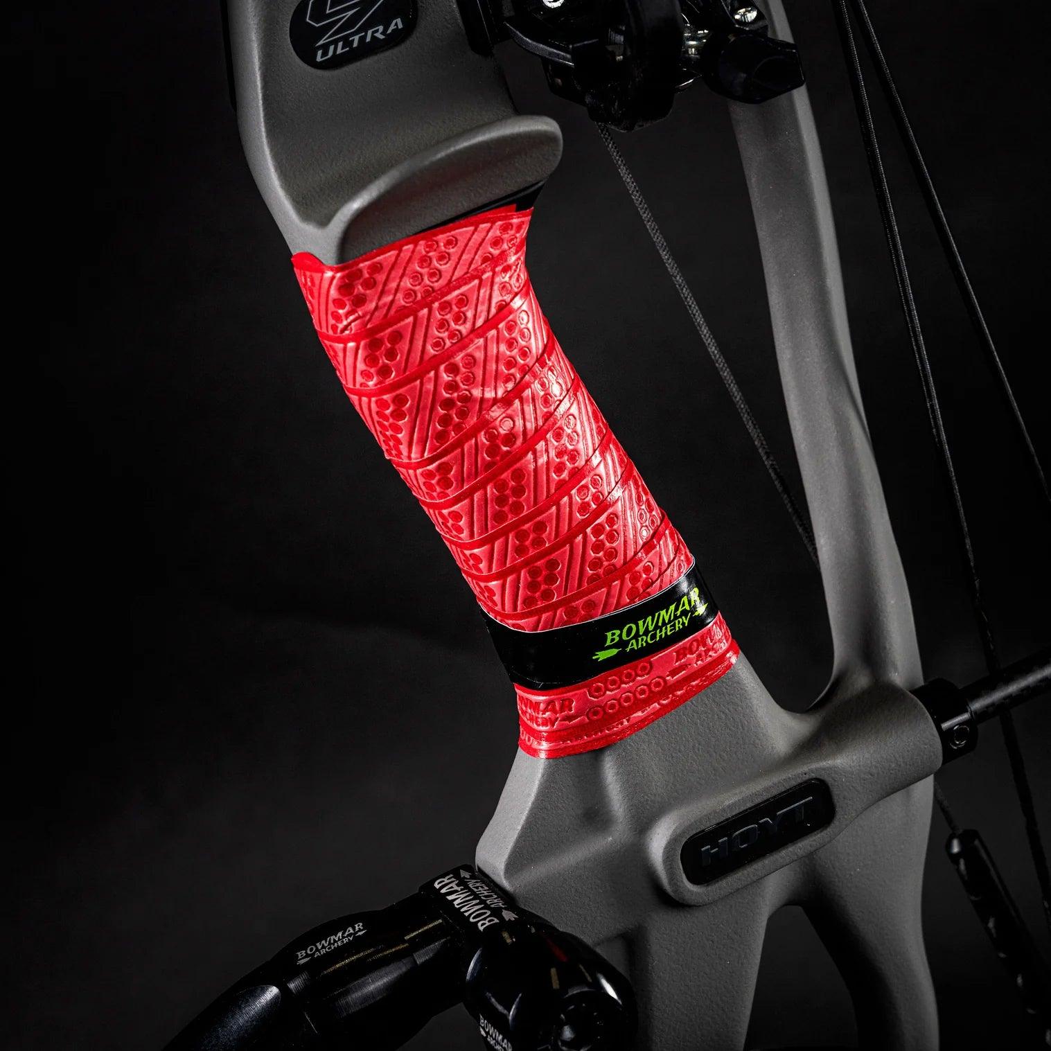 Compound bow riser with red textured grip wrap and Bowmar Archery branding on black background