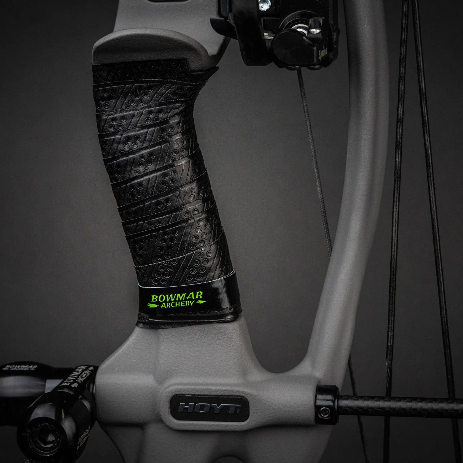 Close-up of a Hoyt compound bow grip with Bowmar Archery black textured wrap.