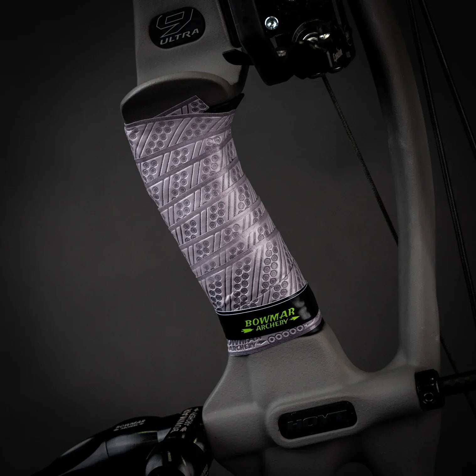 Close-up of a bow grip with textured gray Bowmar Archery wrap on a Hoyt bow