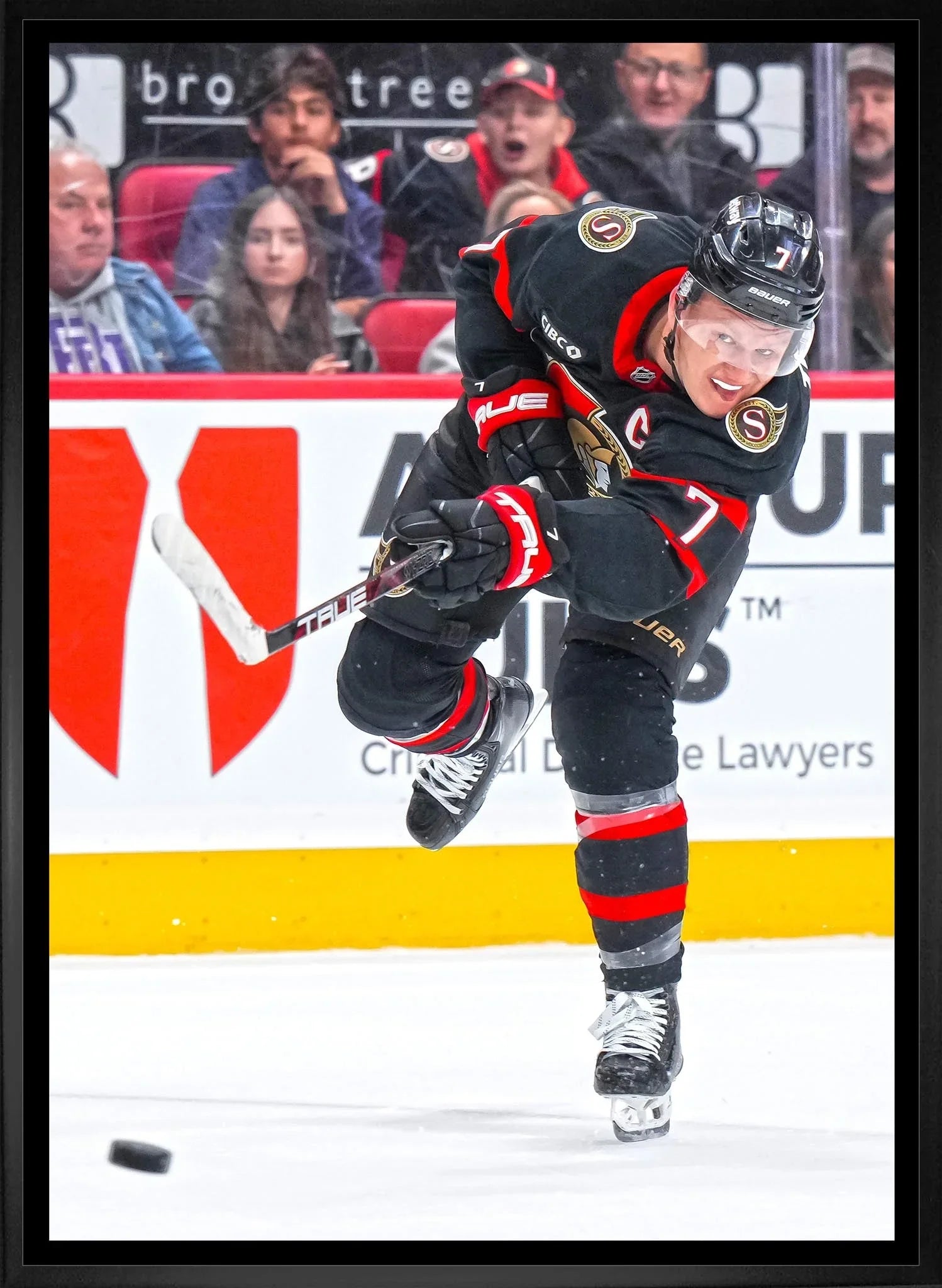 Ottawa Senators hockey player in black jersey shooting puck during game