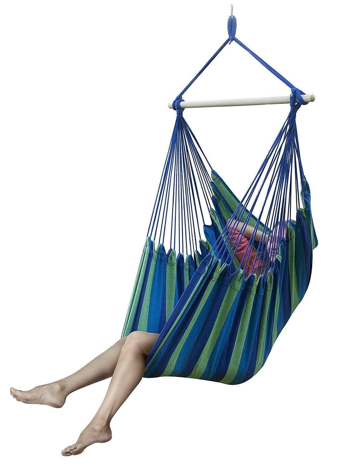Brazilian hammock chair in blue and green stripes with a person relaxing indoors