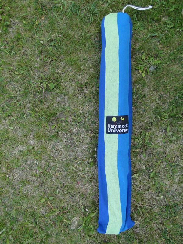 Blue and green striped hammock bag labeled Hammock Universe on grass