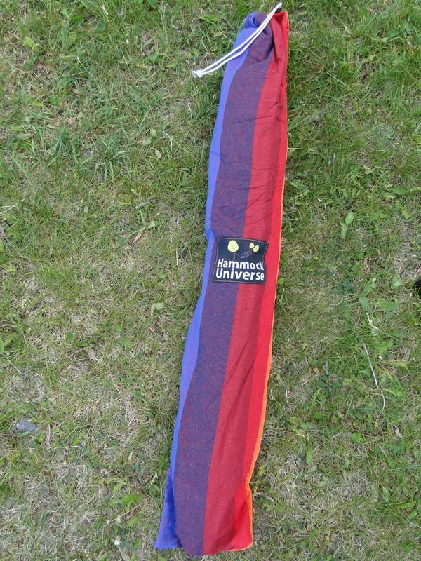 Multicolored striped hammock bag with Hammock Universe logo on grass