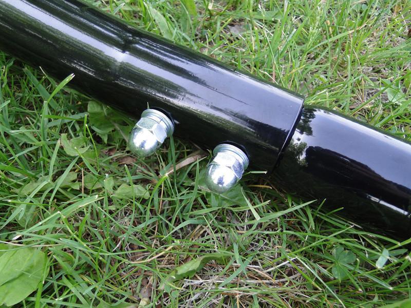 Black metal hammock chair stand joint with bolts on green grass
