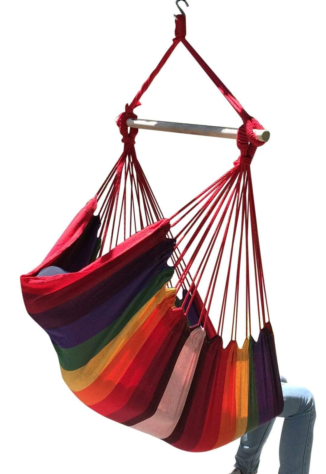 Colorful Brazilian hammock chair with red ropes, wooden bar, and person sitting inside