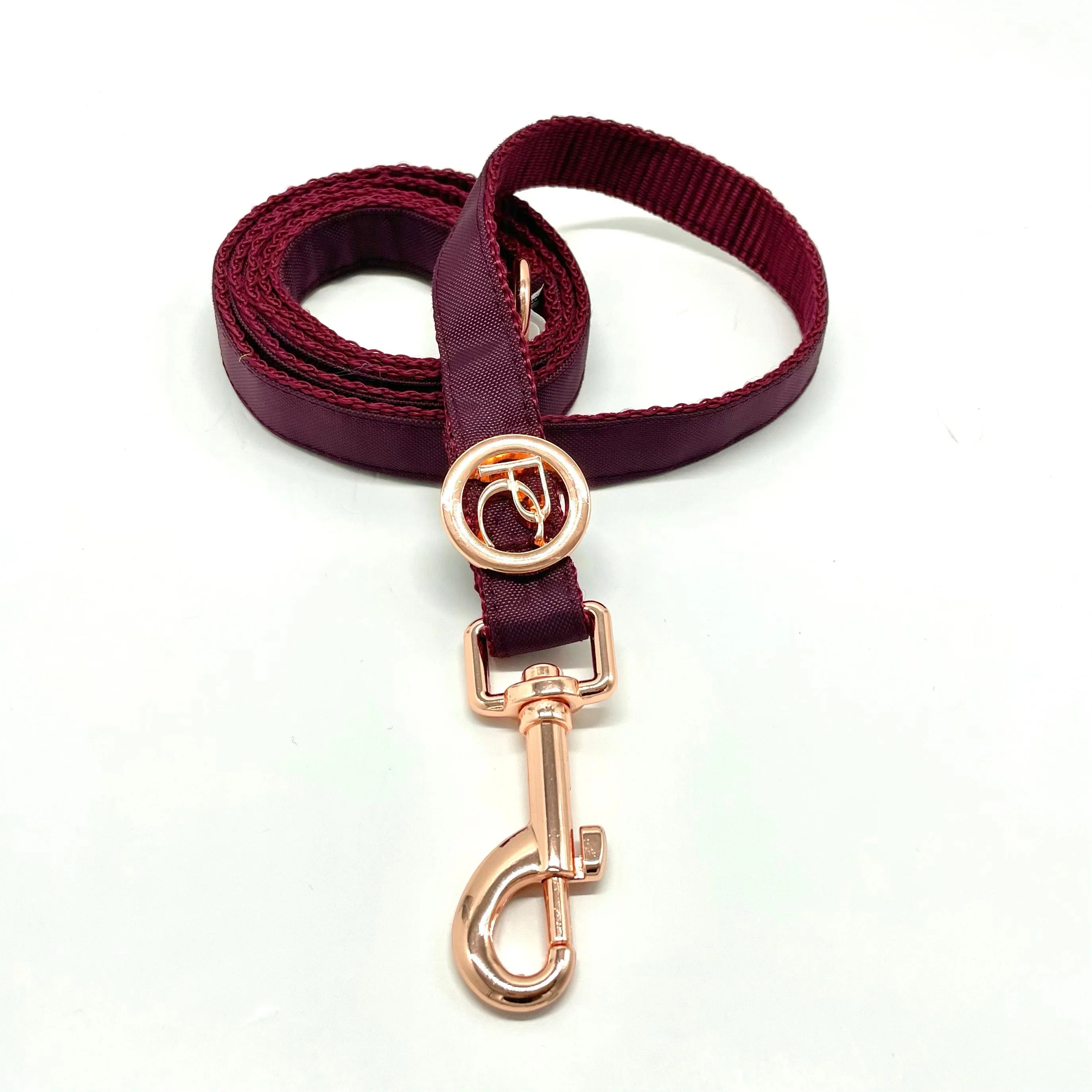 Burgundy dog leash with rose gold clasp and ring on white background