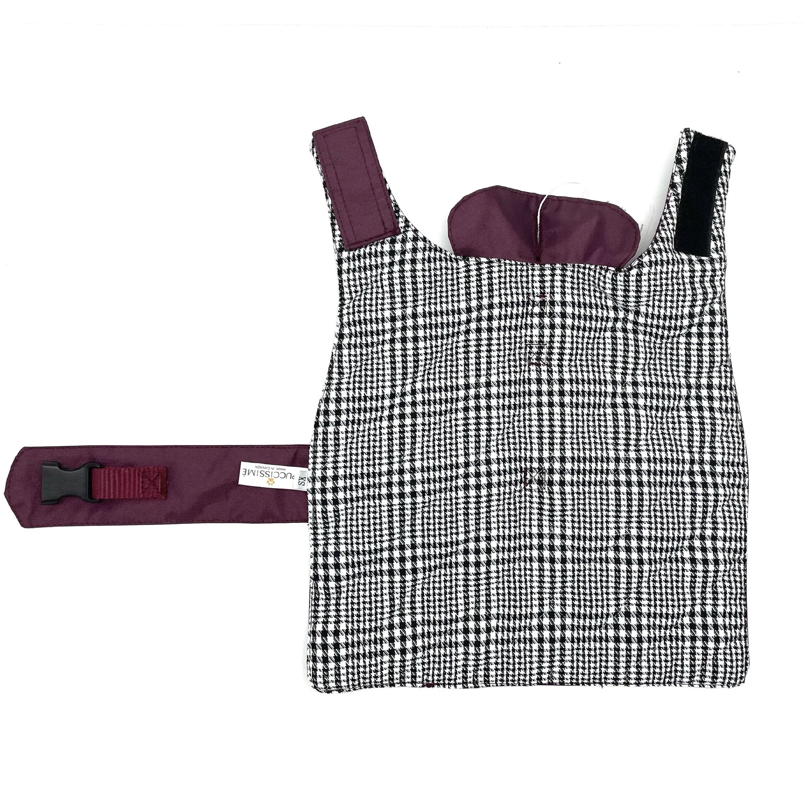 Black and white houndstooth dog harness with maroon strap and buckle on white background