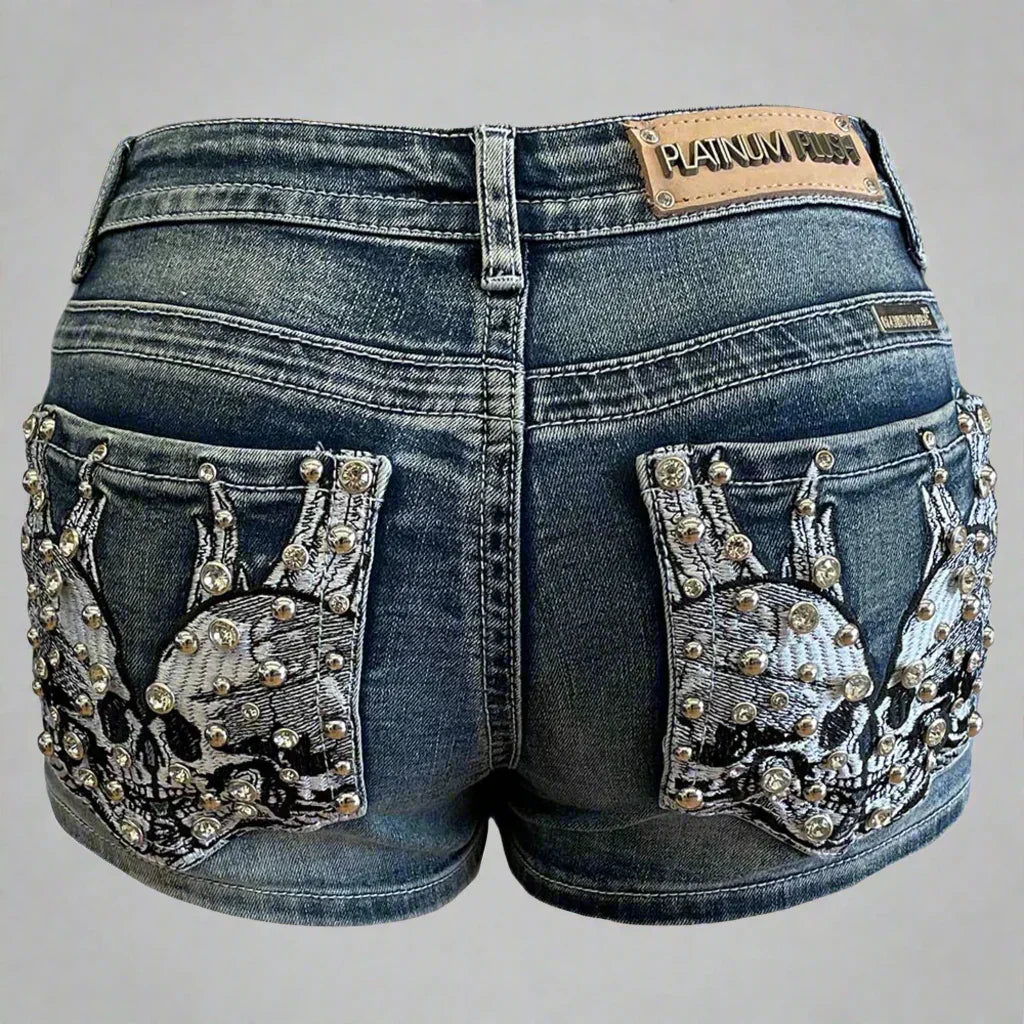 Back of denim shorts with rhinestone-studded skull embroidery on pockets