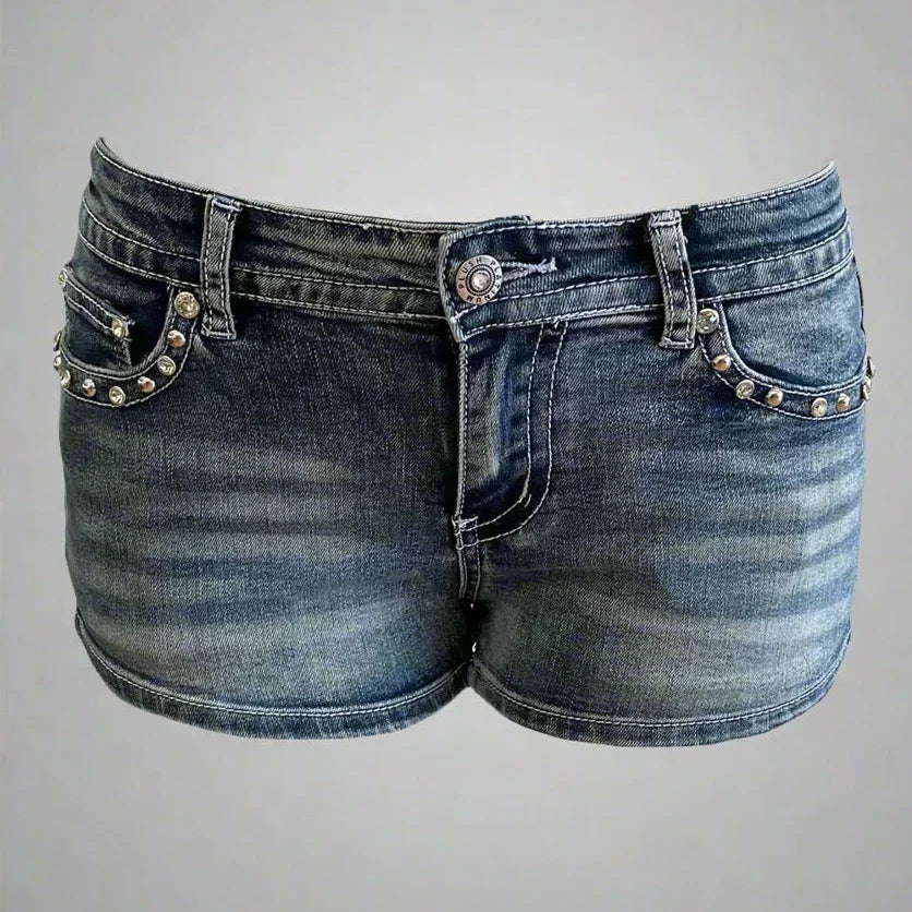 Blue denim shorts with studded pockets, faded wash, and button closure on gray background