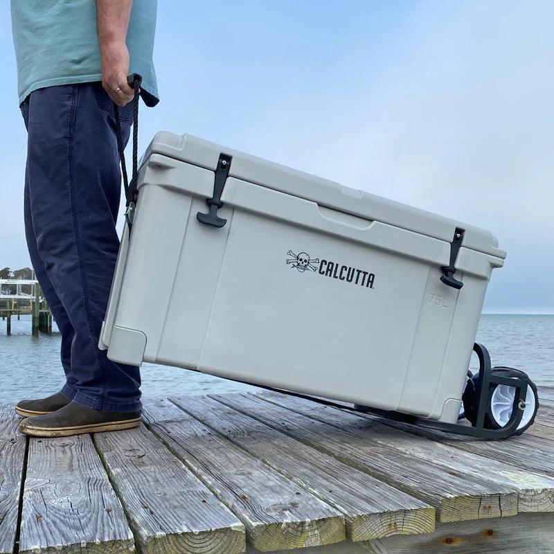 Man pulling Calcutta wheeled cooler on dock by water