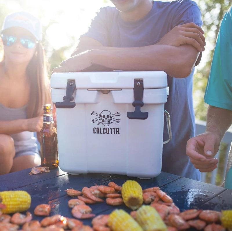 Calcutta white shrimp cooler outdoors with people, shrimp, and corn on picnic table