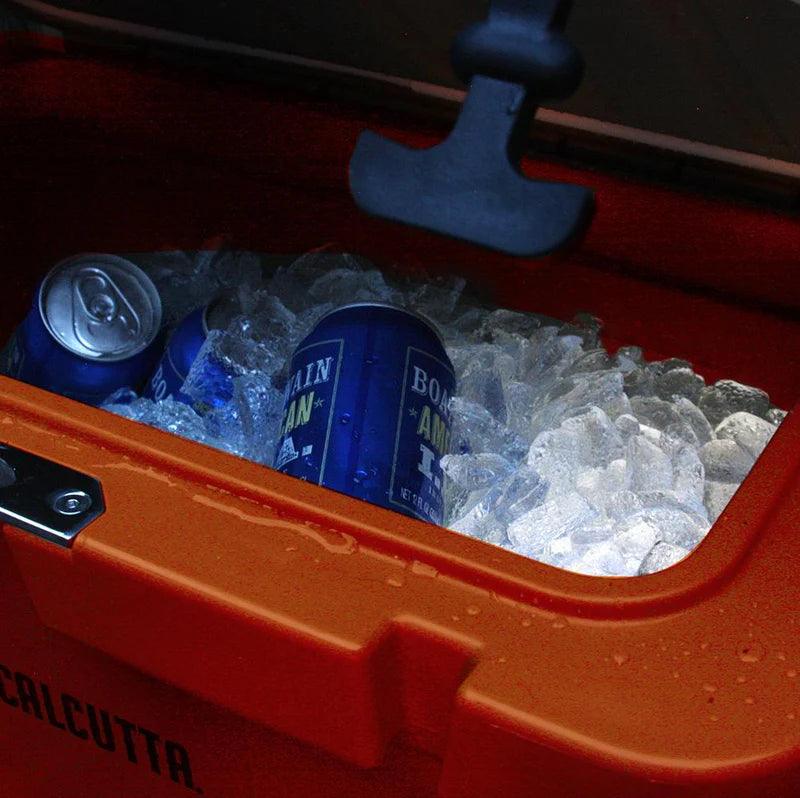 Blue soda cans in ice inside an open orange Calcutta cooler