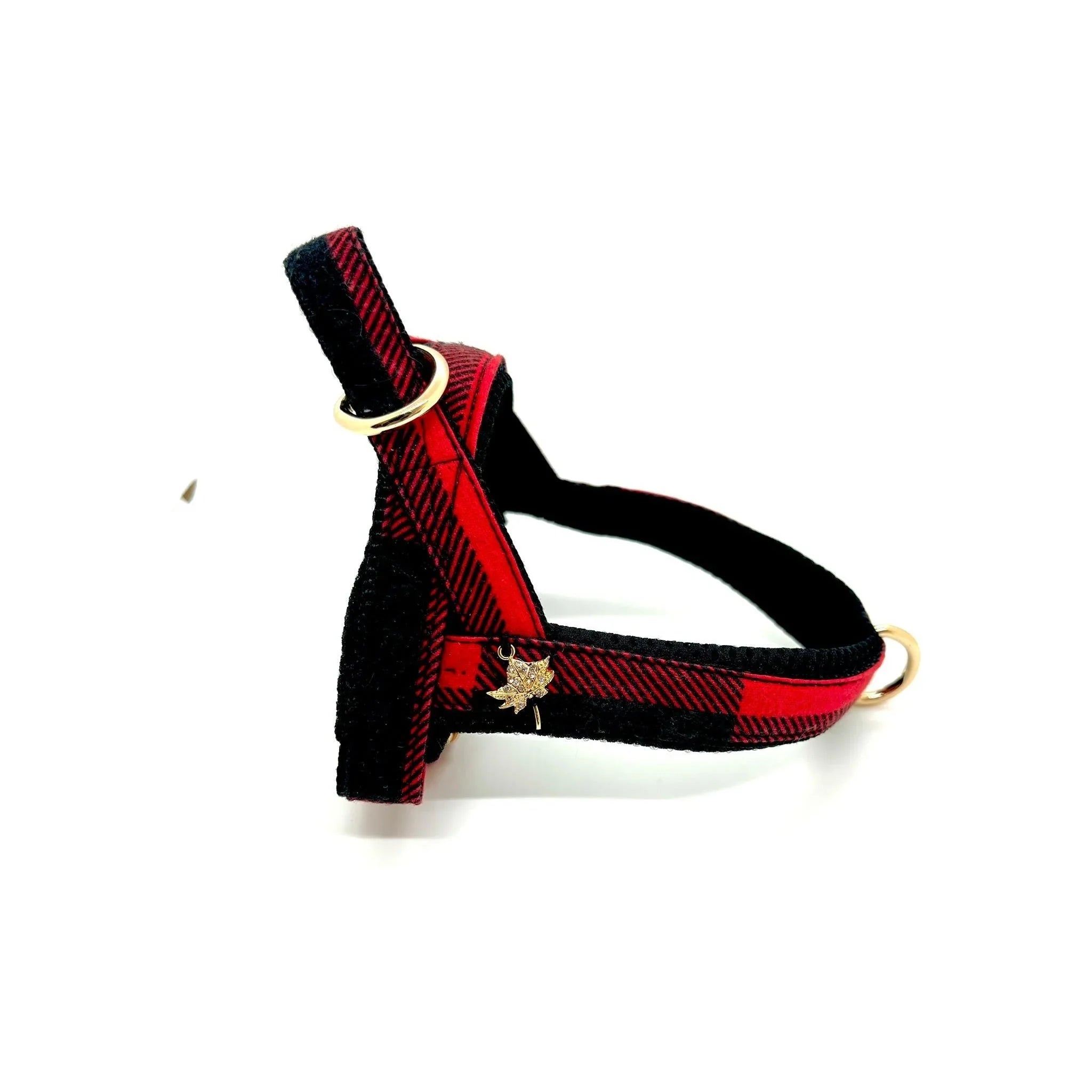 Red and black plaid dog harness with gold hardware and maple leaf charm on white background