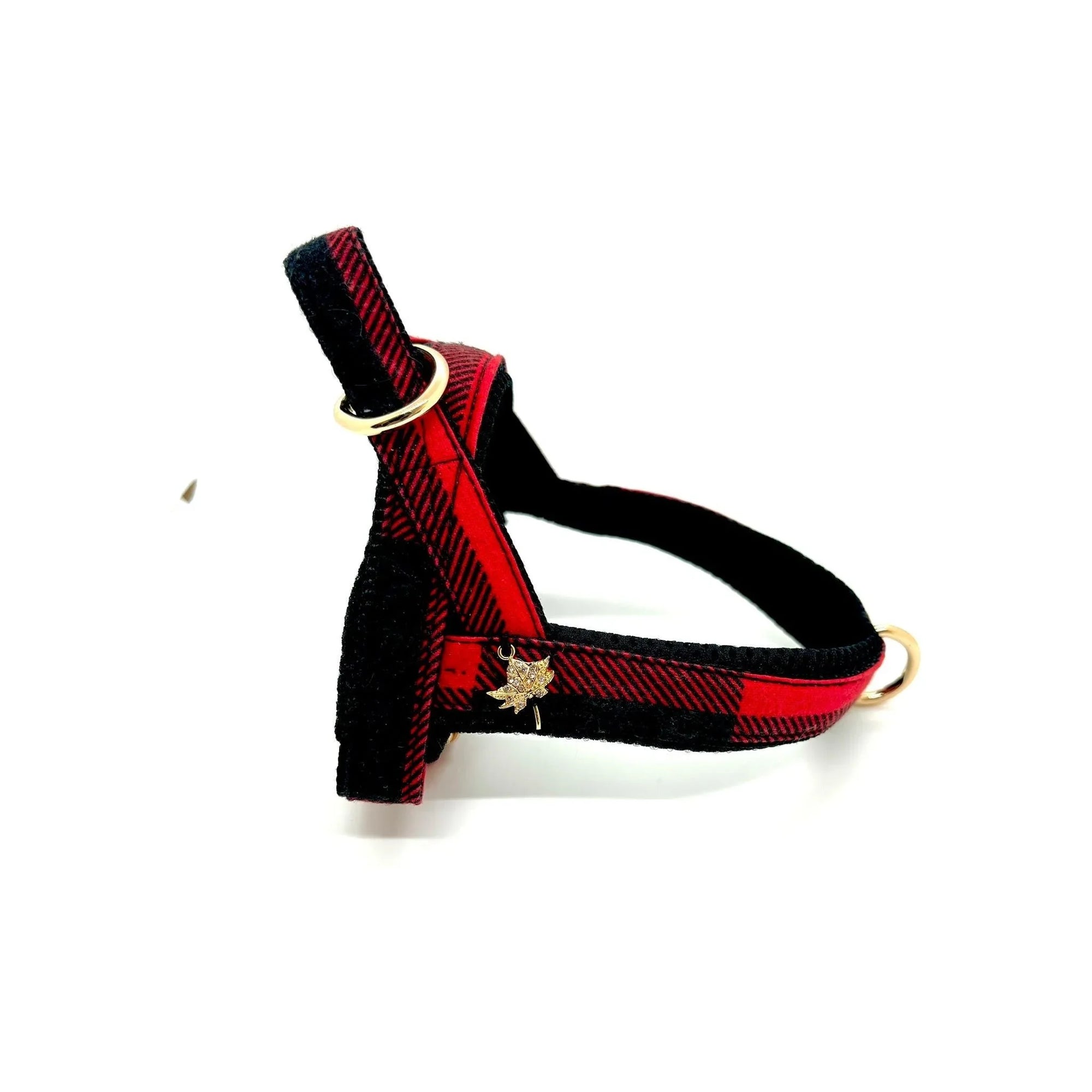 Red and black plaid dog harness with gold hardware and maple leaf charm on white background