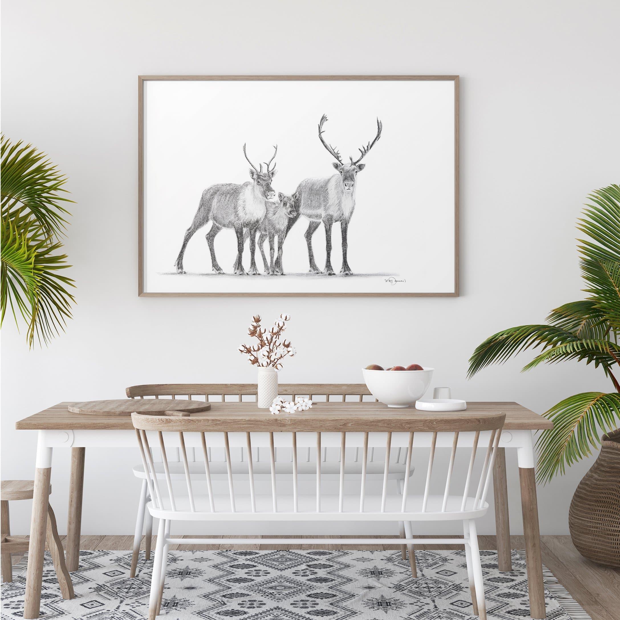 Modern dining room with framed caribou art, wooden table, white chairs, and potted plants