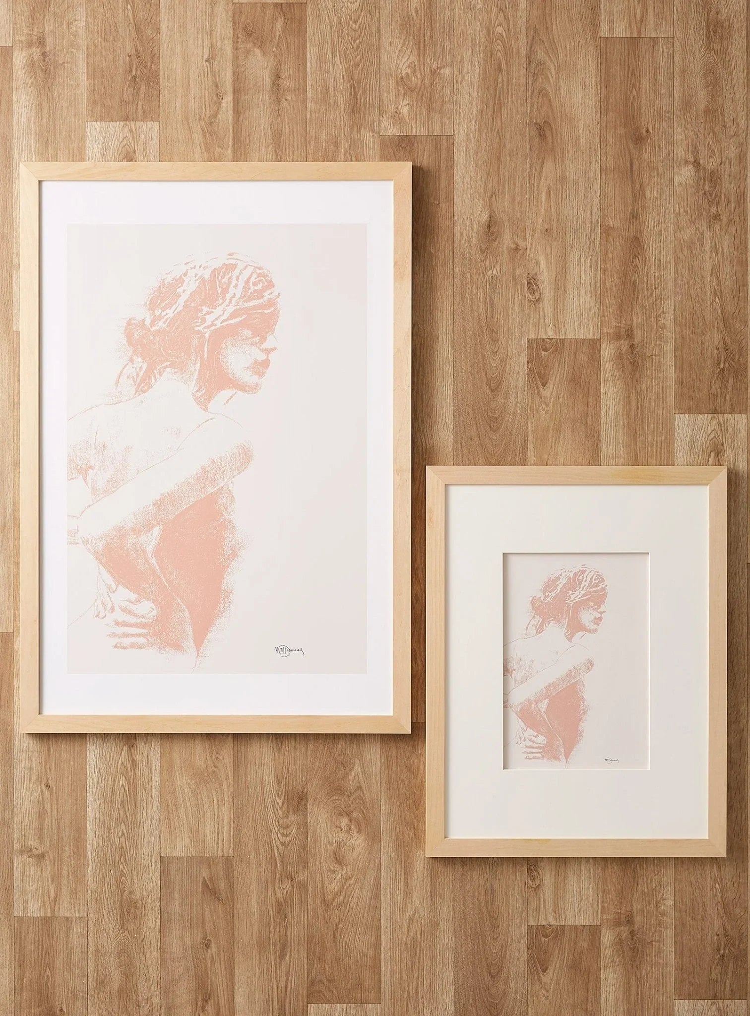 Charcoal women figure art print in light wood frames on wooden floor