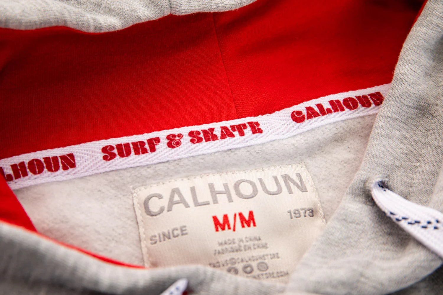 Calhoun grey hoodie with red hood lining and surf & skate branding on inner trim
