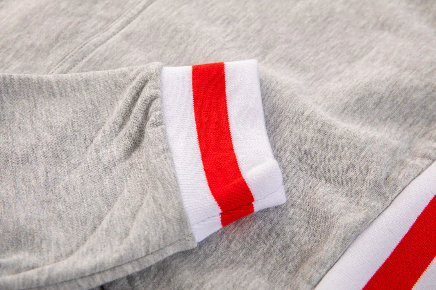 Grey sweatshirt with white and red striped ribbed cuff and waistband trim detail