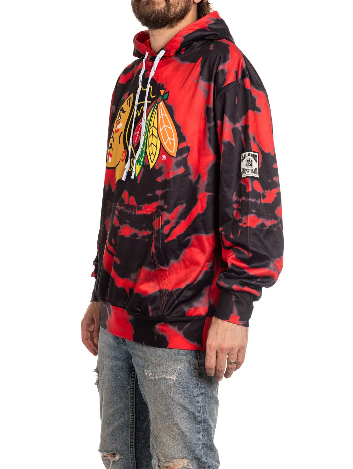 Man wearing red and black tie-dye Chicago hockey team hoodie with distressed jeans