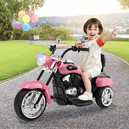Smiling child riding a pink toy electric motorcycle outdoors with balloons in background