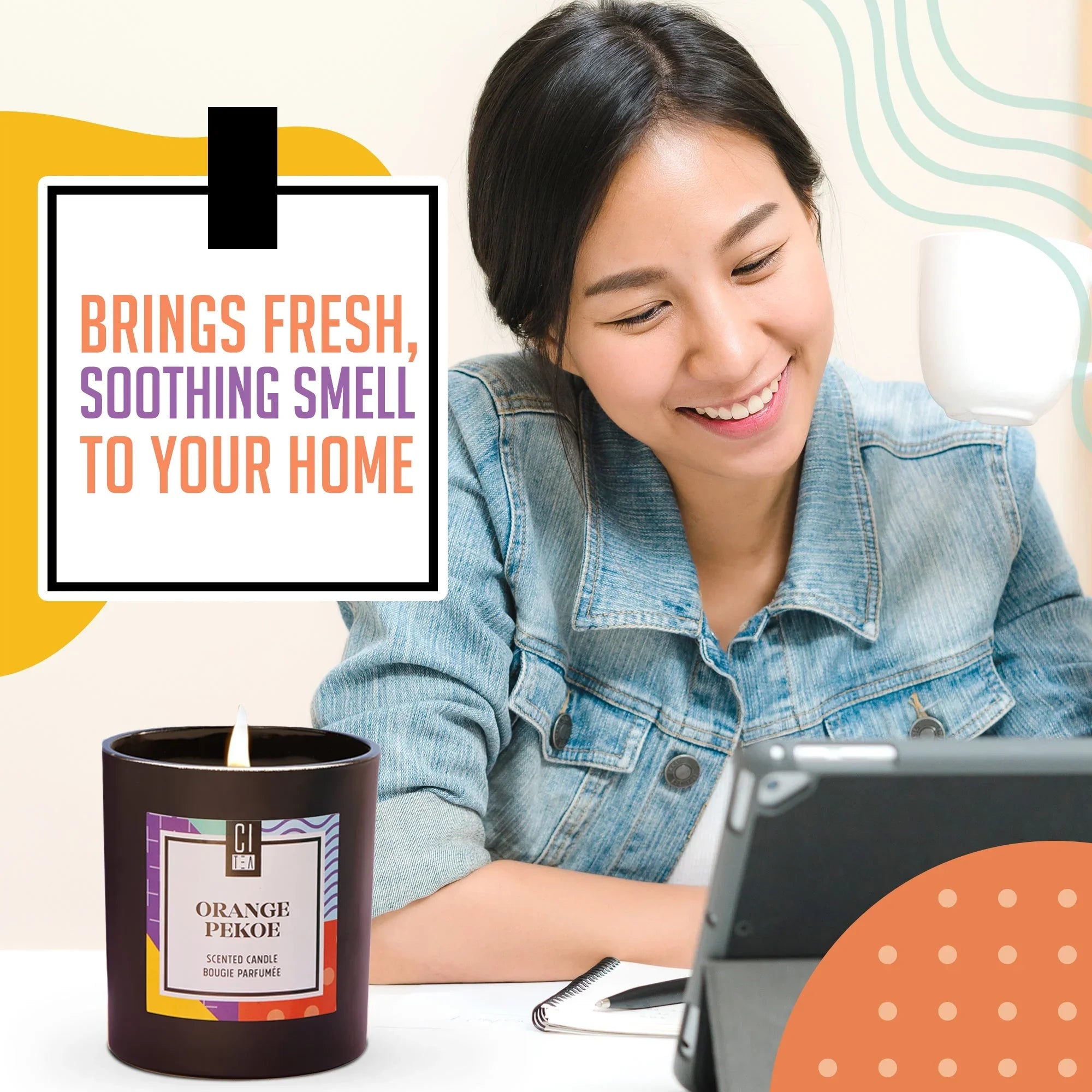 Orange Pekoe soy wax candle on desk with smiling woman, promoting fresh scented home atmosphere