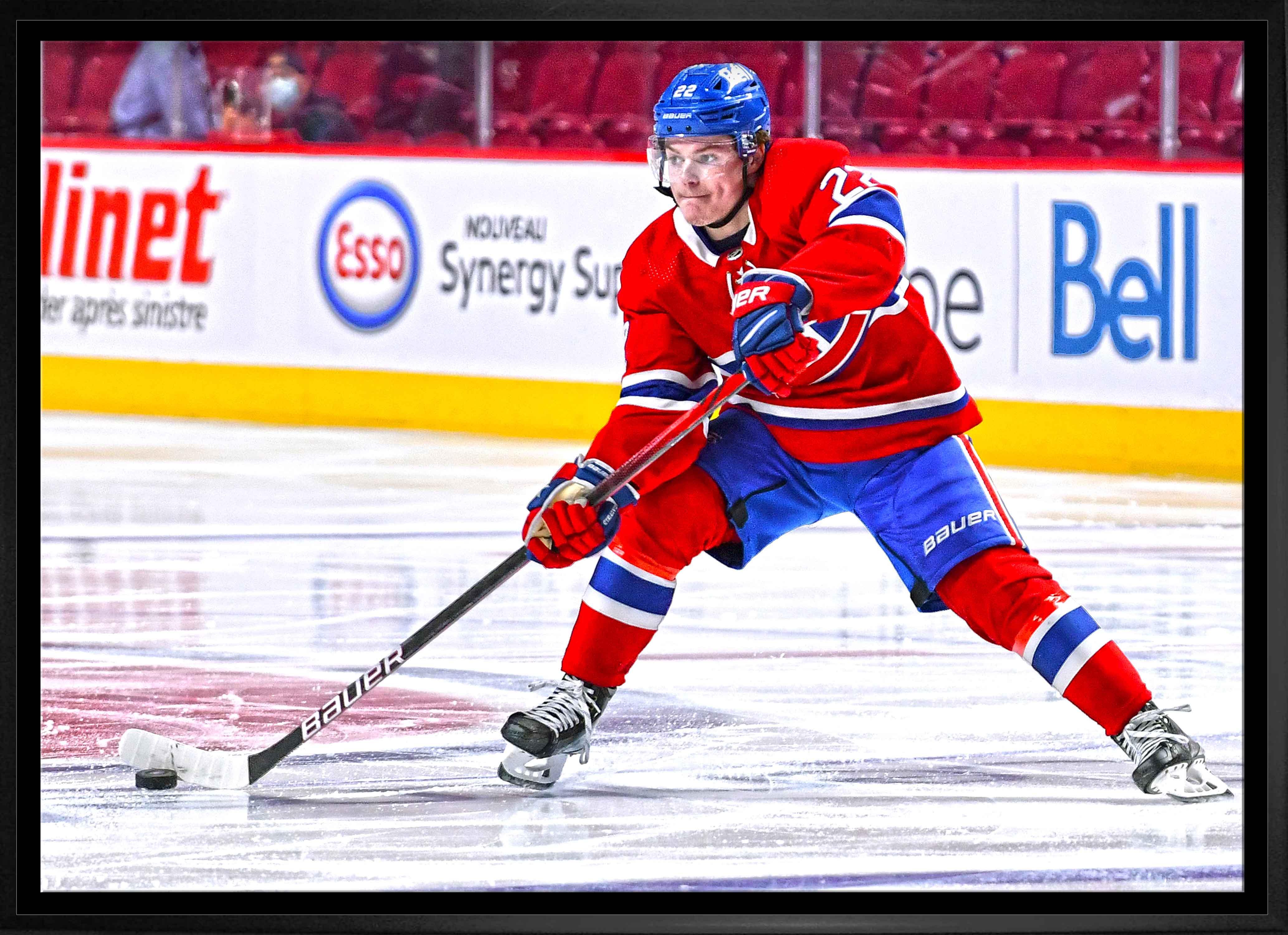 Ice hockey player in red Montreal Canadiens uniform skating with puck on rink