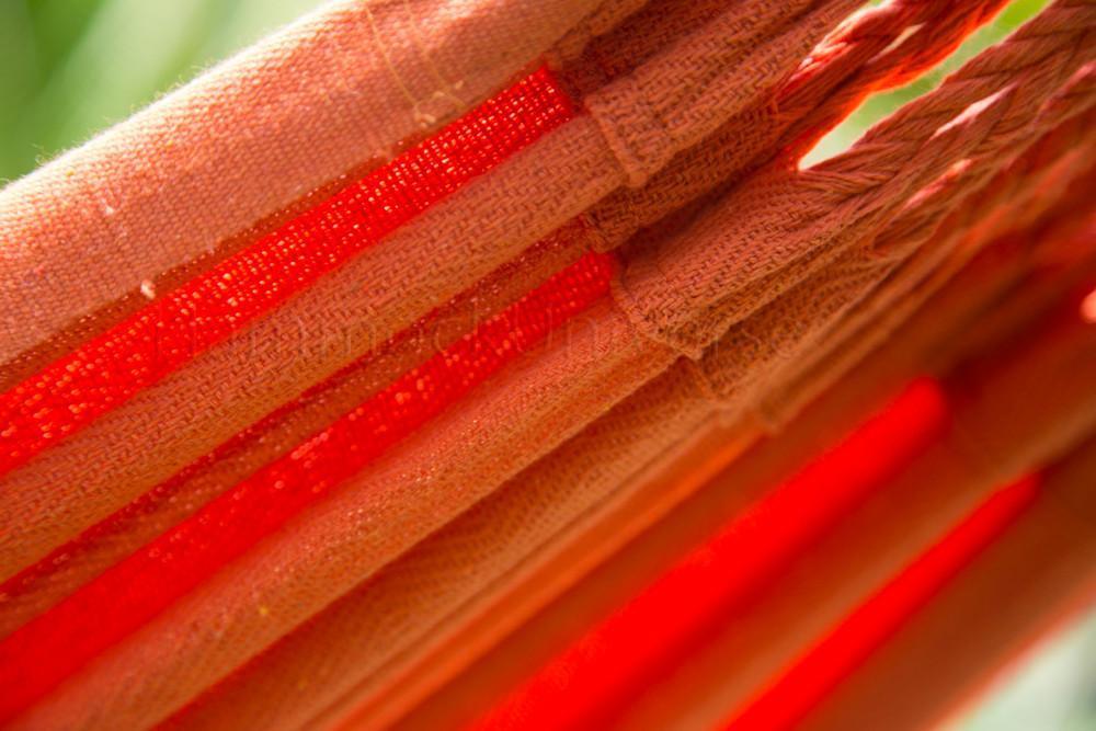 Close-up of orange Colombian hammock fabric with woven texture and natural light.