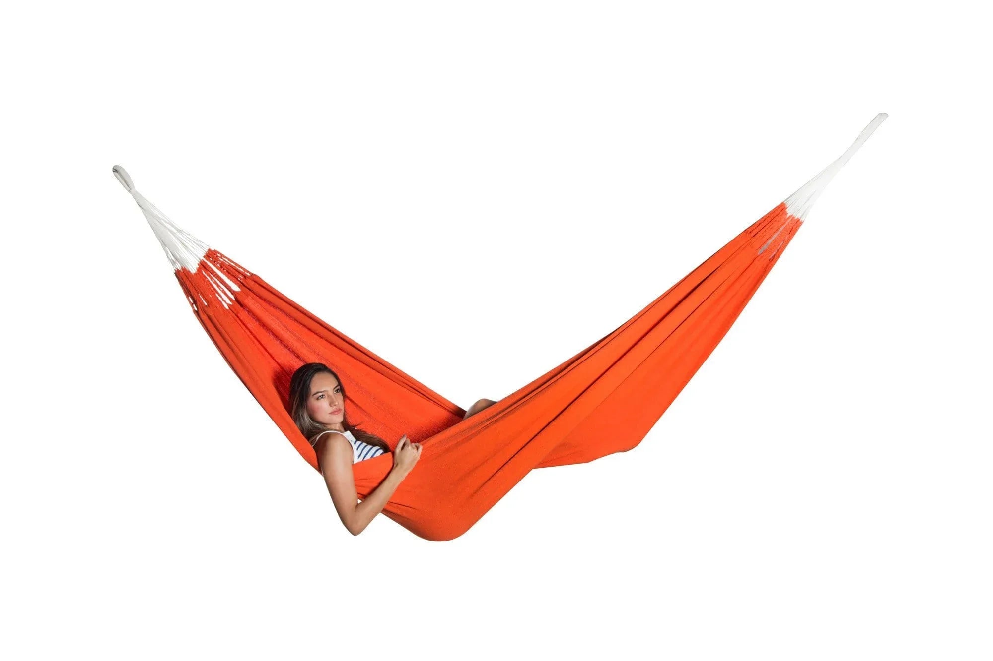 Woman relaxing in a bright orange hammock on a white background