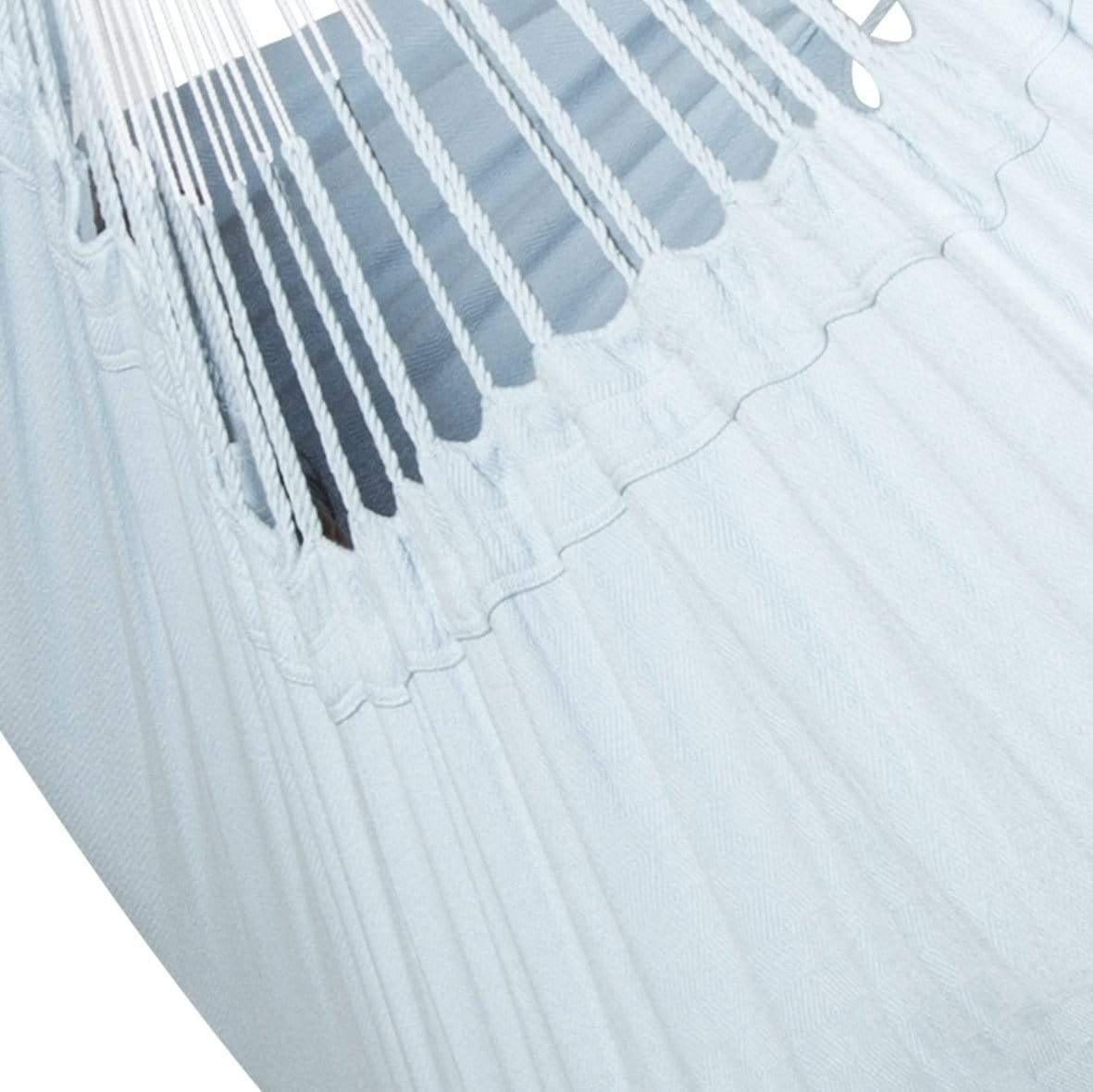 Detail of a white Colombian hammock chair with woven cotton fabric and rope suspension.