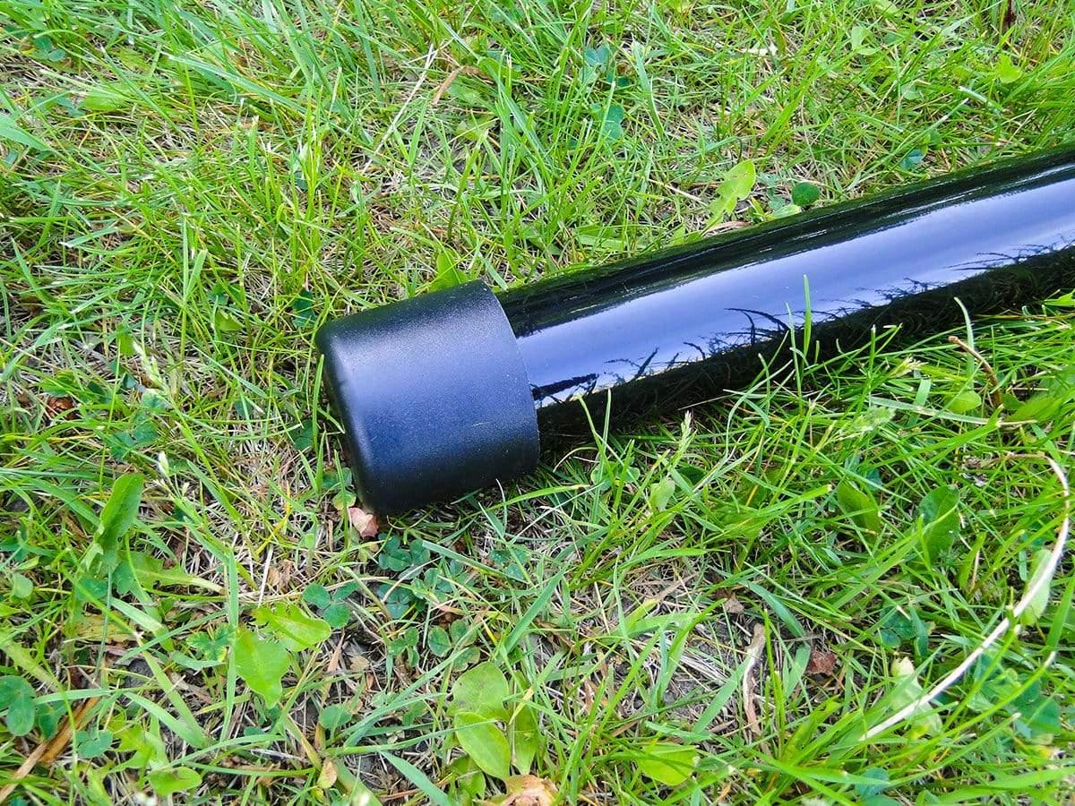 Black metal hammock chair stand leg with cap on green grass outdoors