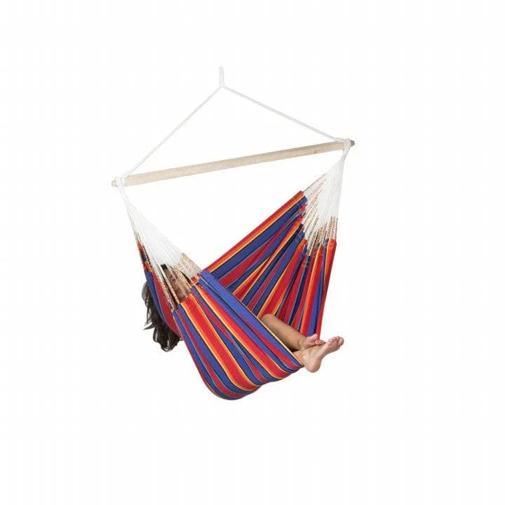 Person relaxing in colorful striped hammock chair against white background