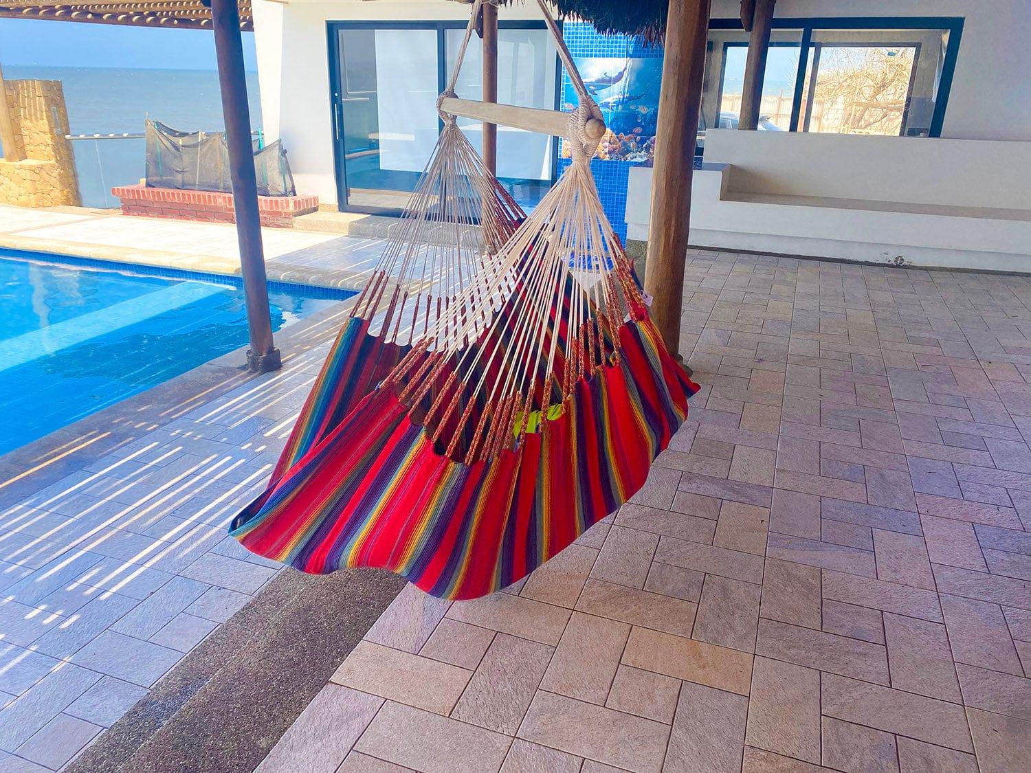Striped hammock chair by poolside patio with ocean view