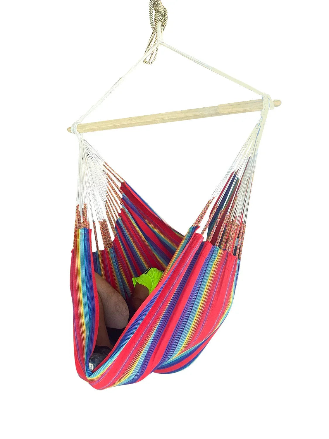 Colorful striped hammock chair with wooden bar and rope suspension, person reclining inside.
